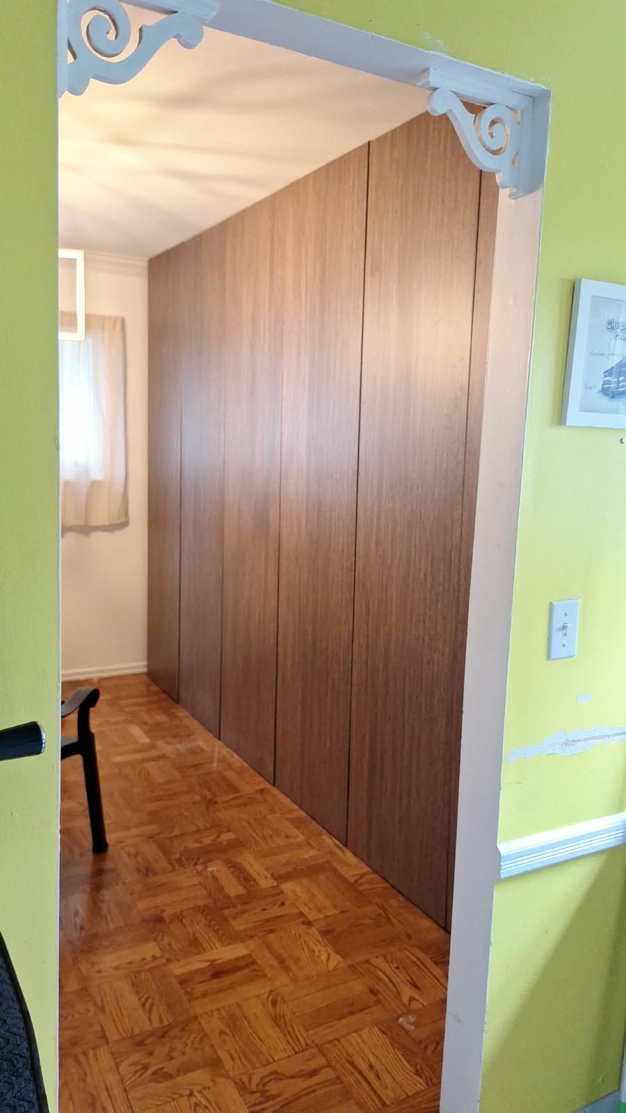 Installed wood-finish wardrobe front panels viewed from the doorway