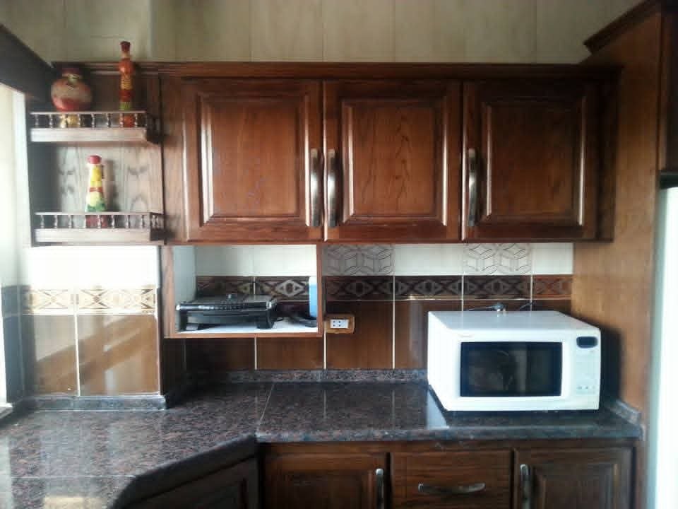 Raised-panel upper cabinets and an open appliance shelf