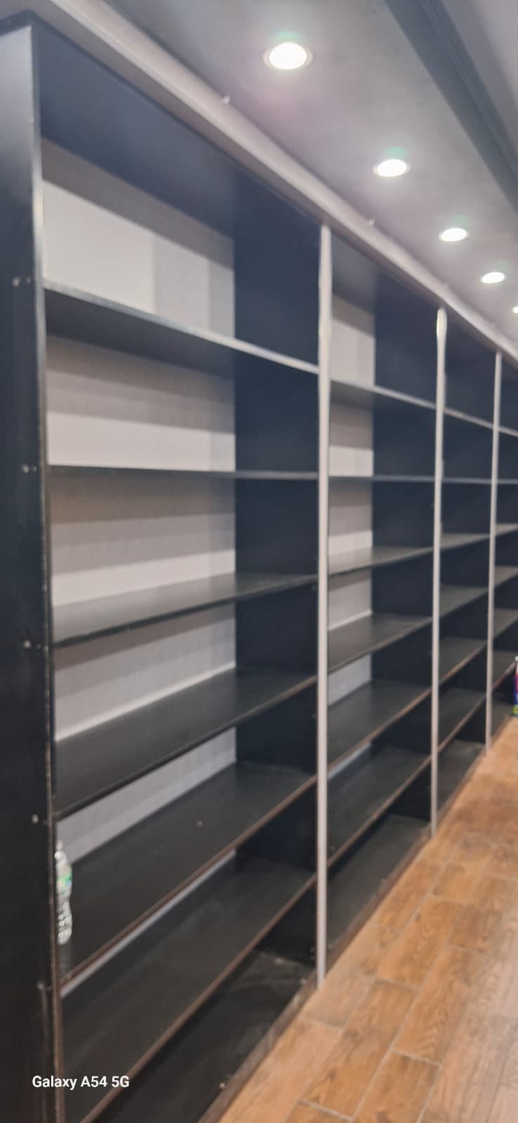 Long run of dark retail display shelves