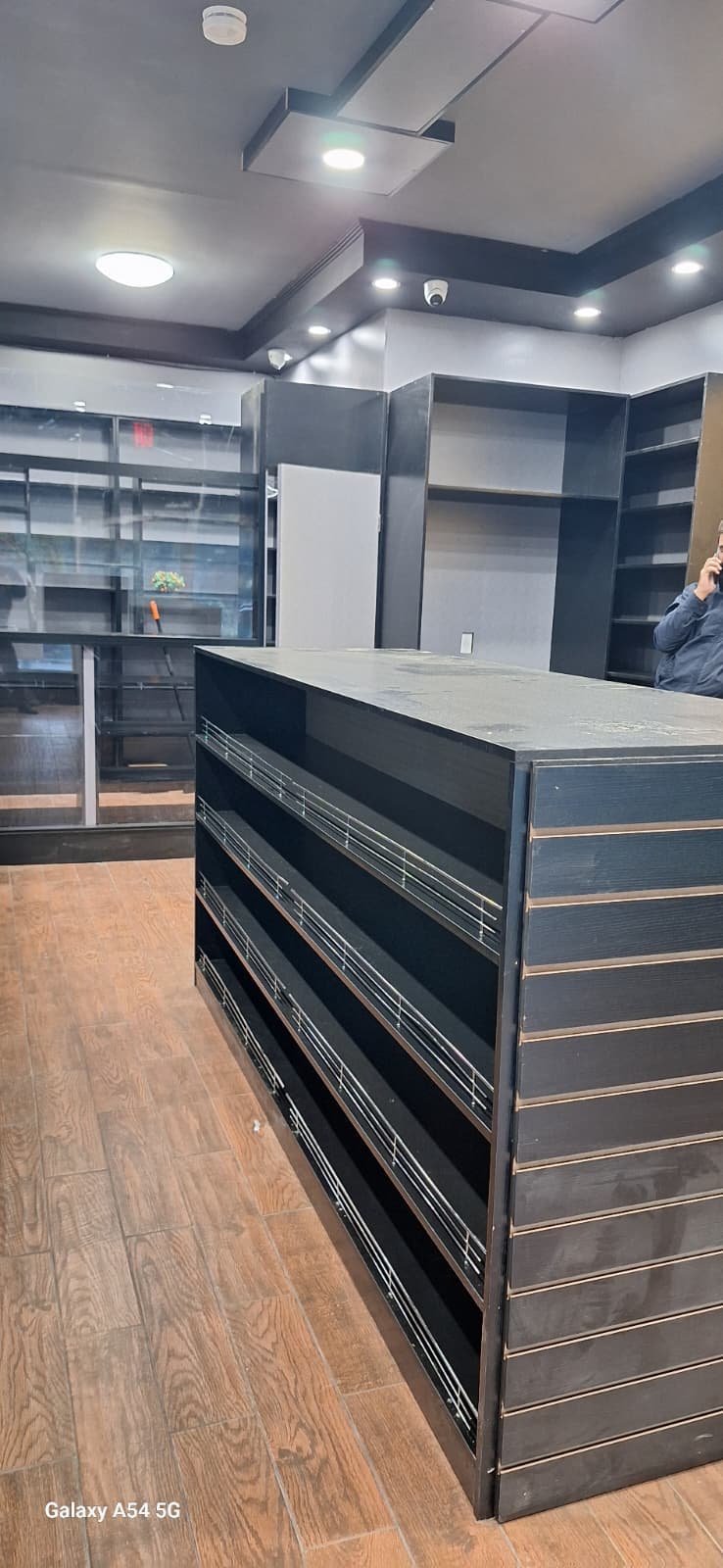 Dark retail counter with display shelves and metal rails
